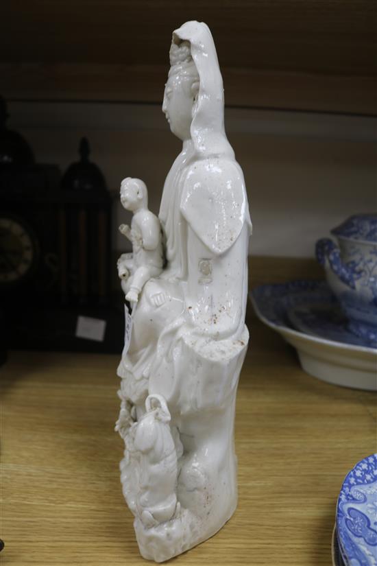 A large Chinese blanc de chine group of Guanyin and child, Kangxi period, damage and losses